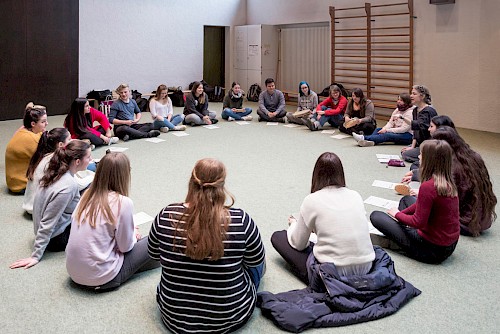 2018 – Schülerinnen und Schüler im Gymnastikraum der Evangelischen Fachschule beim Unterricht Schülerinnen und Schüler sitzen im Kreis auf dem Boden im Gymnastikraum der Evangelischen Fachschule beim Unterricht